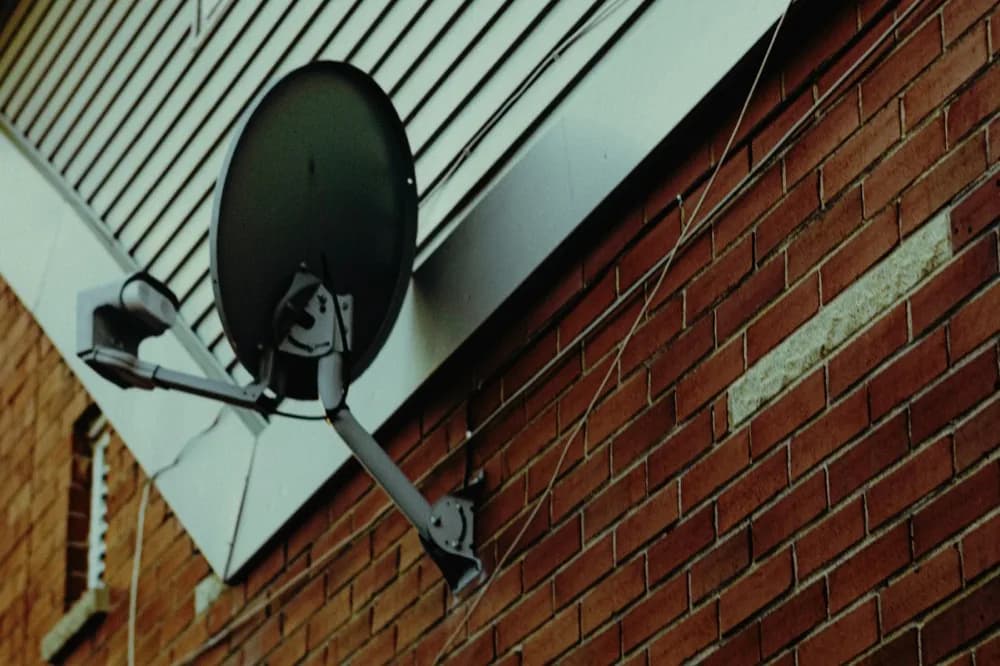 Antenne parabolique fixée sur un mur de brique