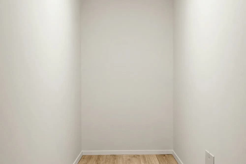 Angle d'une pièce vide, plancher de bois et plinthe blanche
