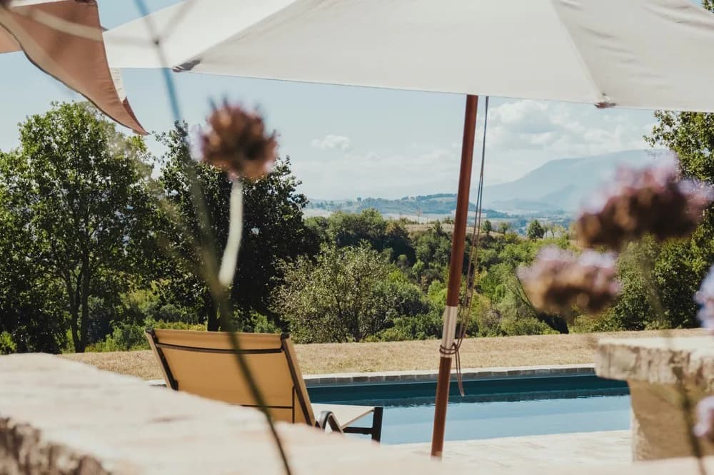 Parasol blanc et banc de béton au bord d'un bassin