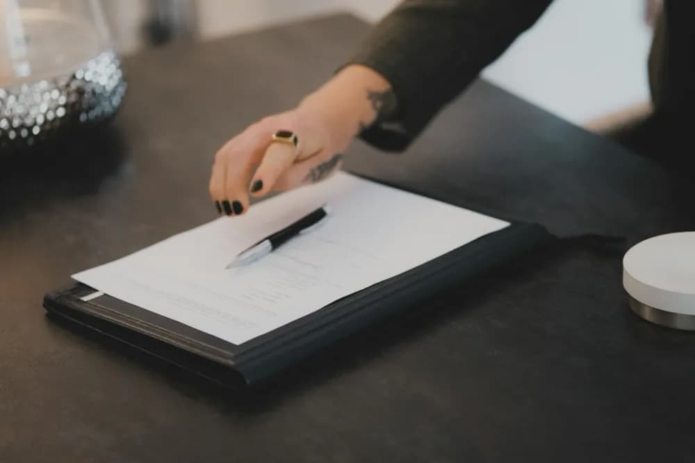 Main qui remplit un formulaire posé sur une table